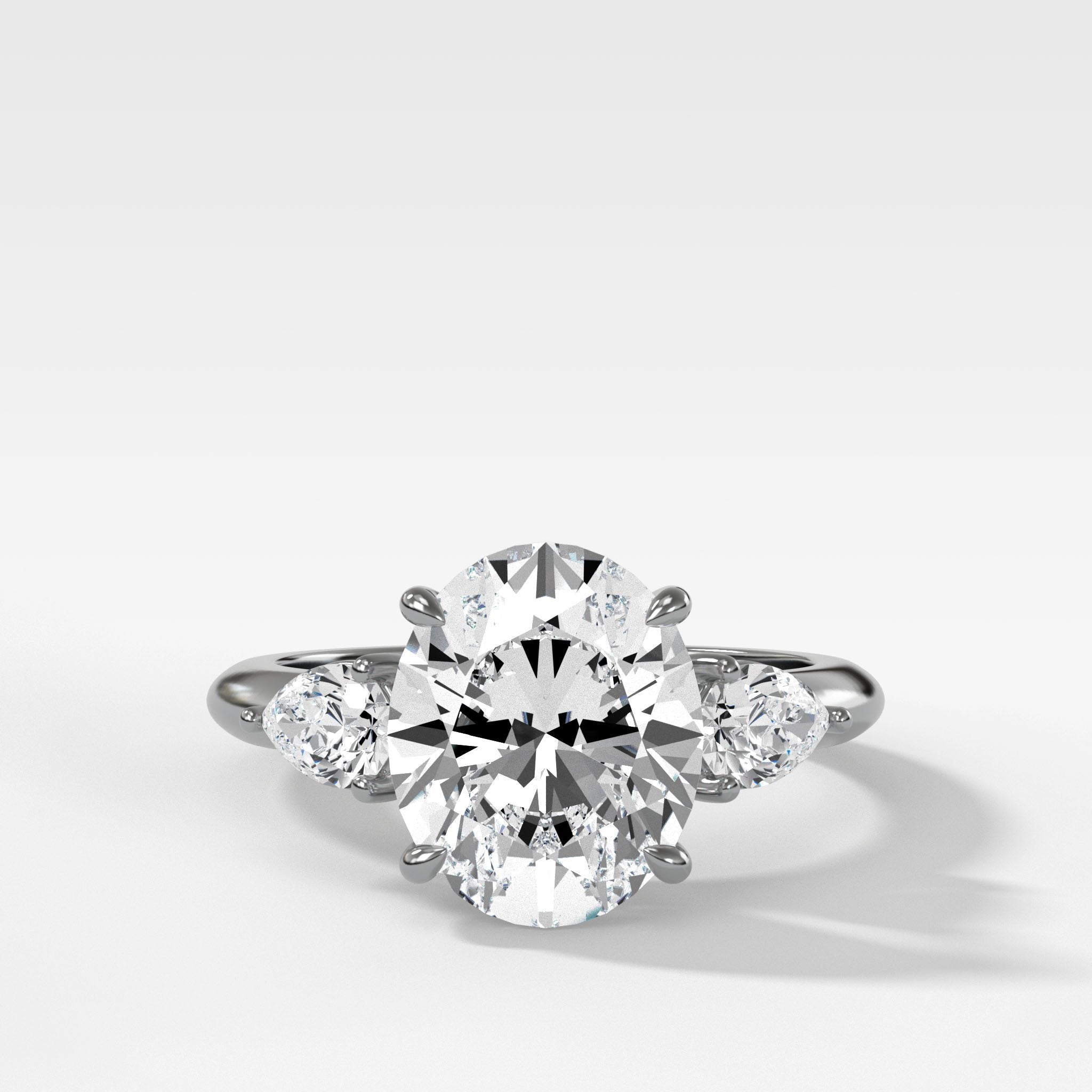 Three Stone Engagement Ring With Pear Side Stones and Oval Cut Diamond