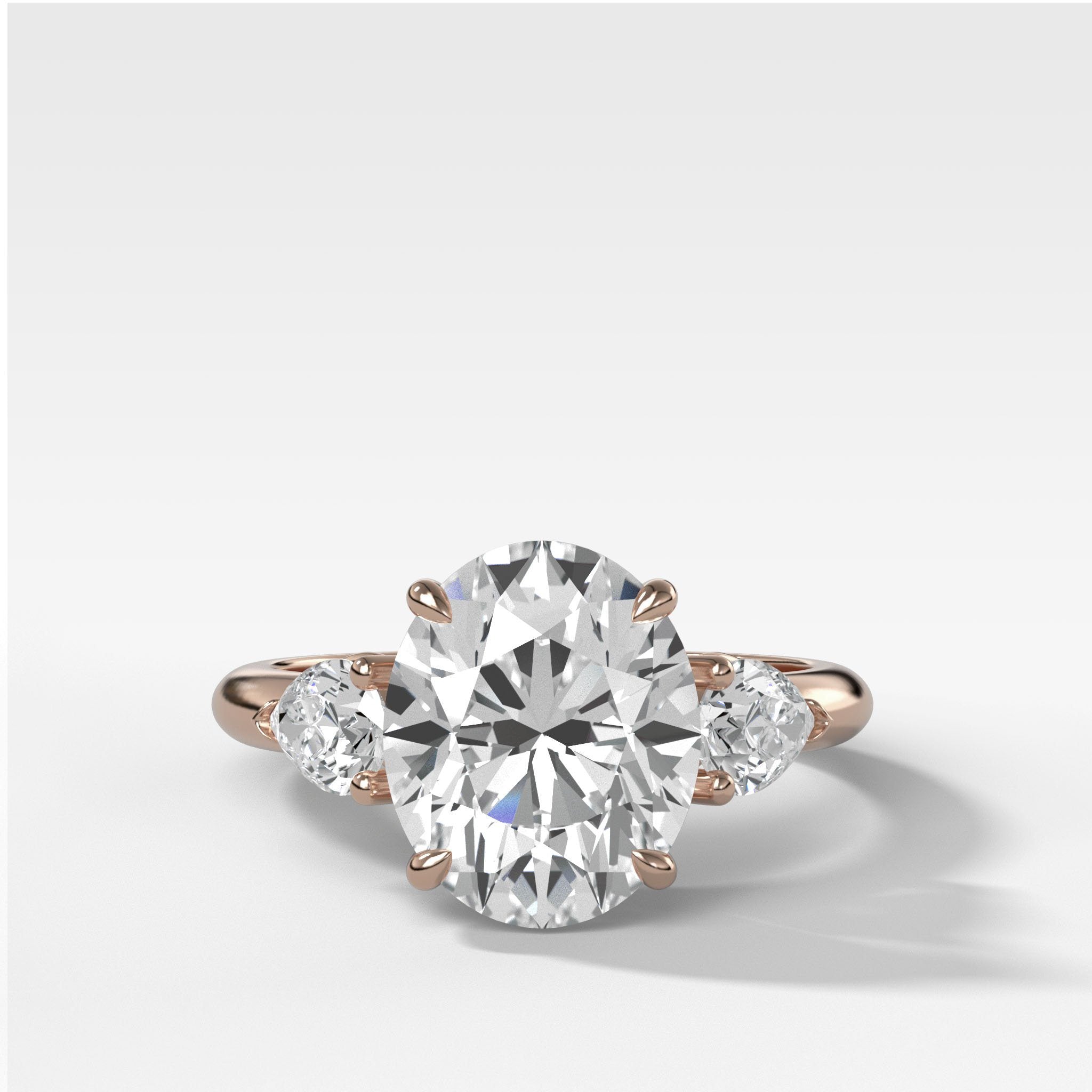Three Stone Engagement Ring With Pear Side Stones and Oval Cut Diamond