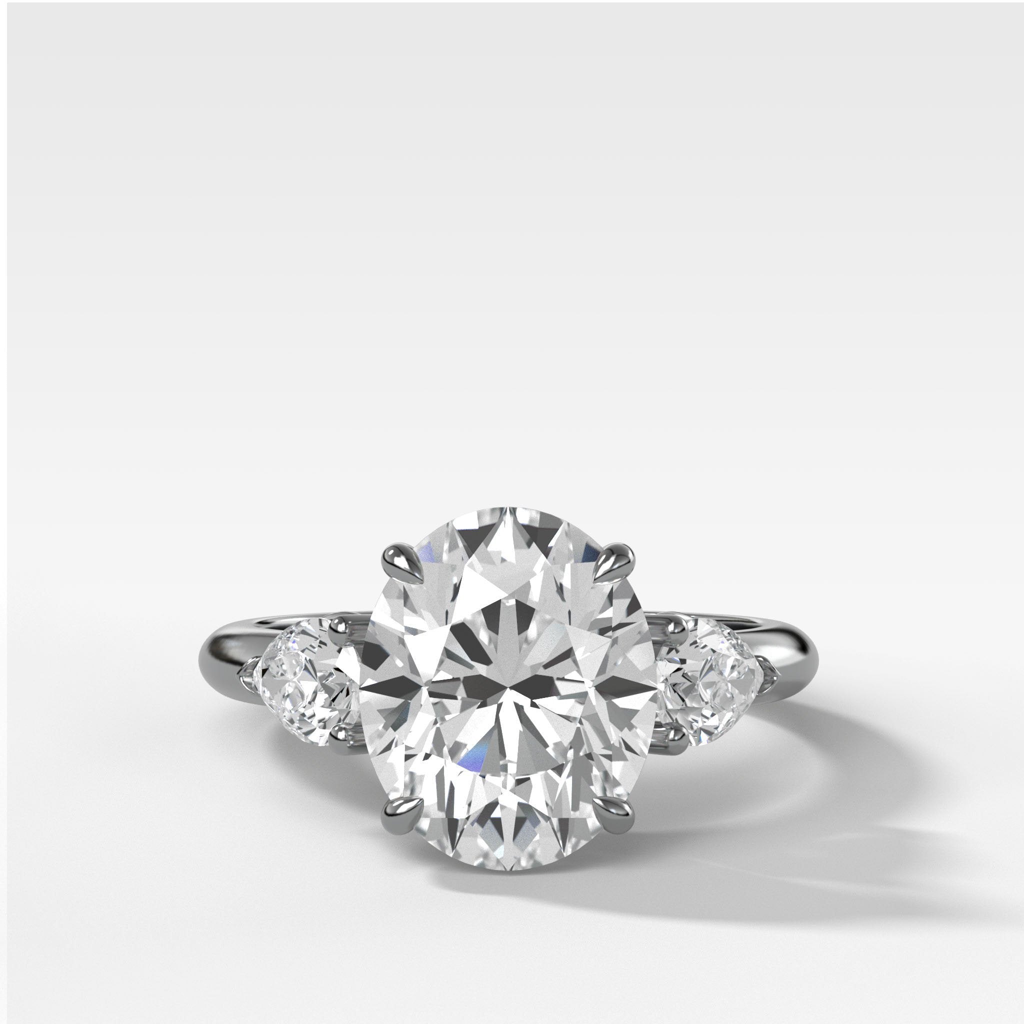 Three Stone Engagement Ring With Pear Side Stones and Oval Cut Diamond