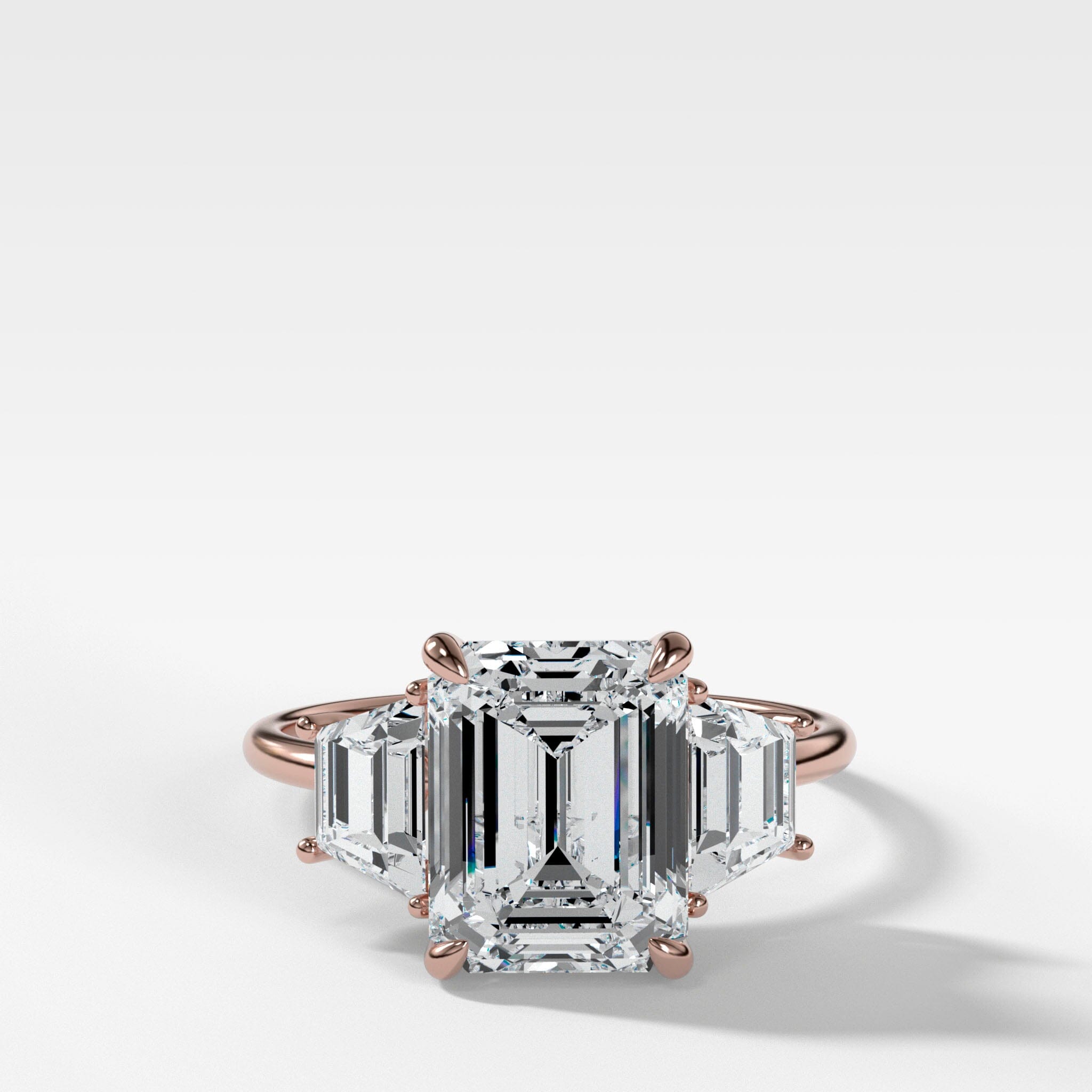 Three Stone ring with Trapezoid side diamonds and an Emerald cut