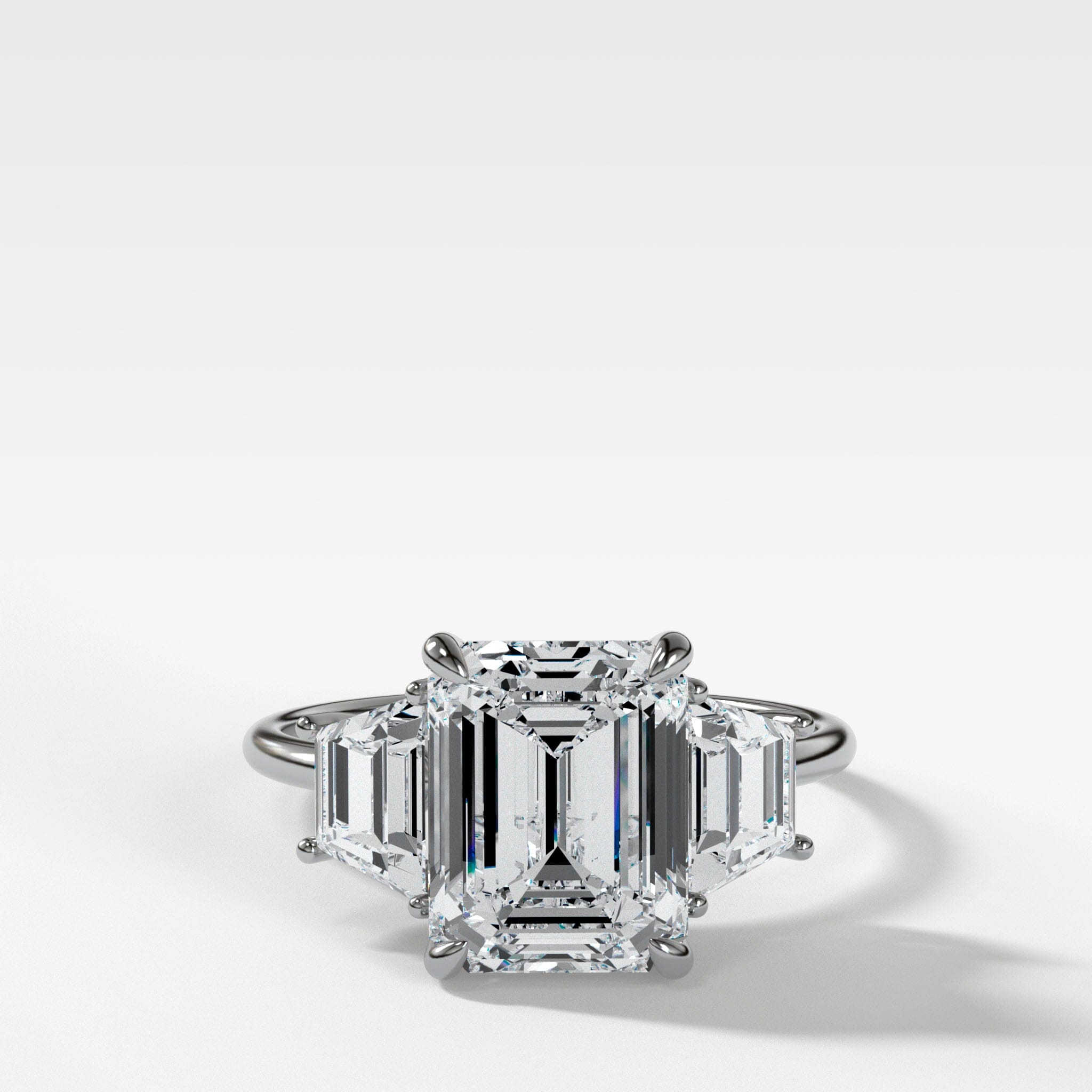 Three Stone ring with Trapezoid side diamonds and an Emerald cut