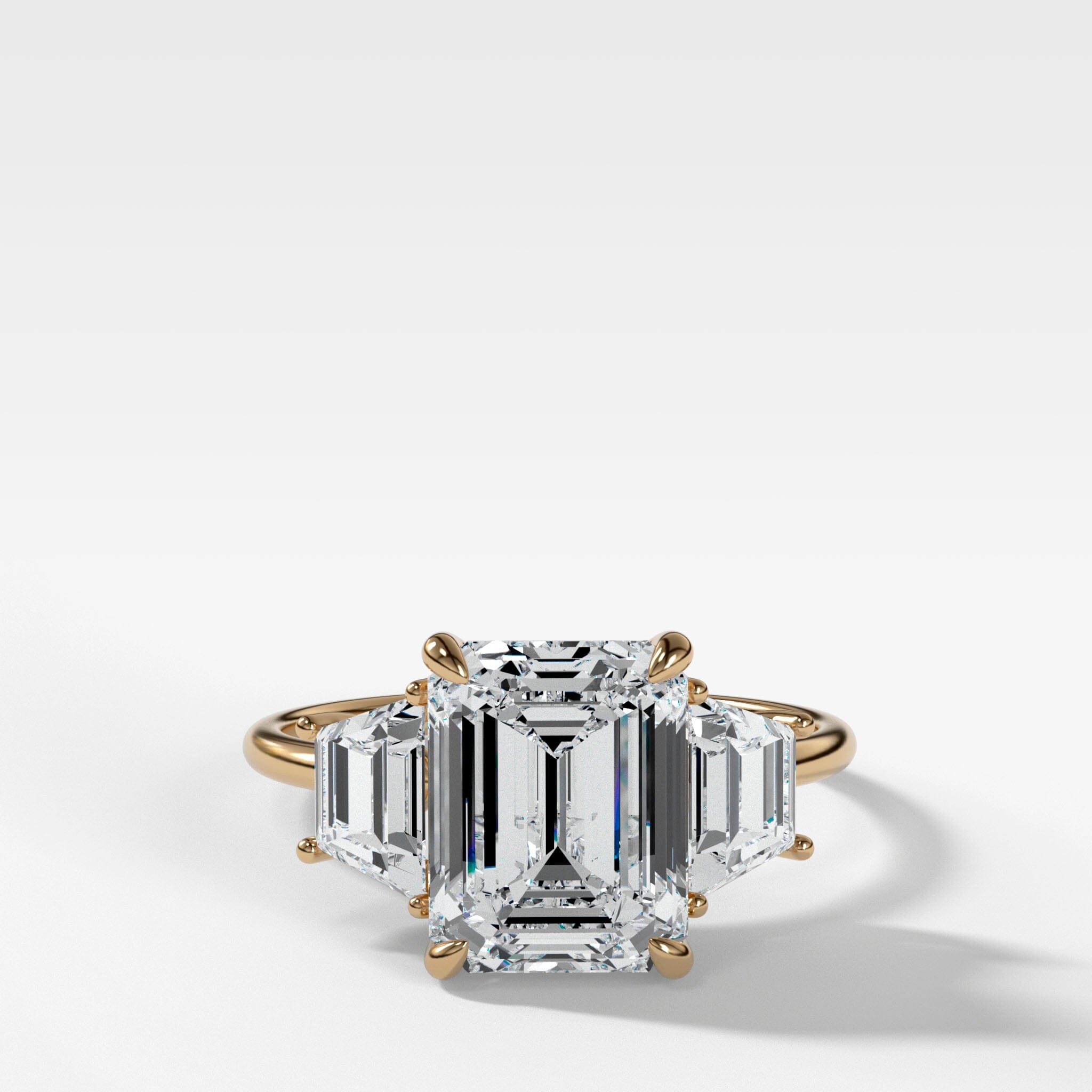 Three Stone ring with Trapezoid side diamonds and an Emerald cut
