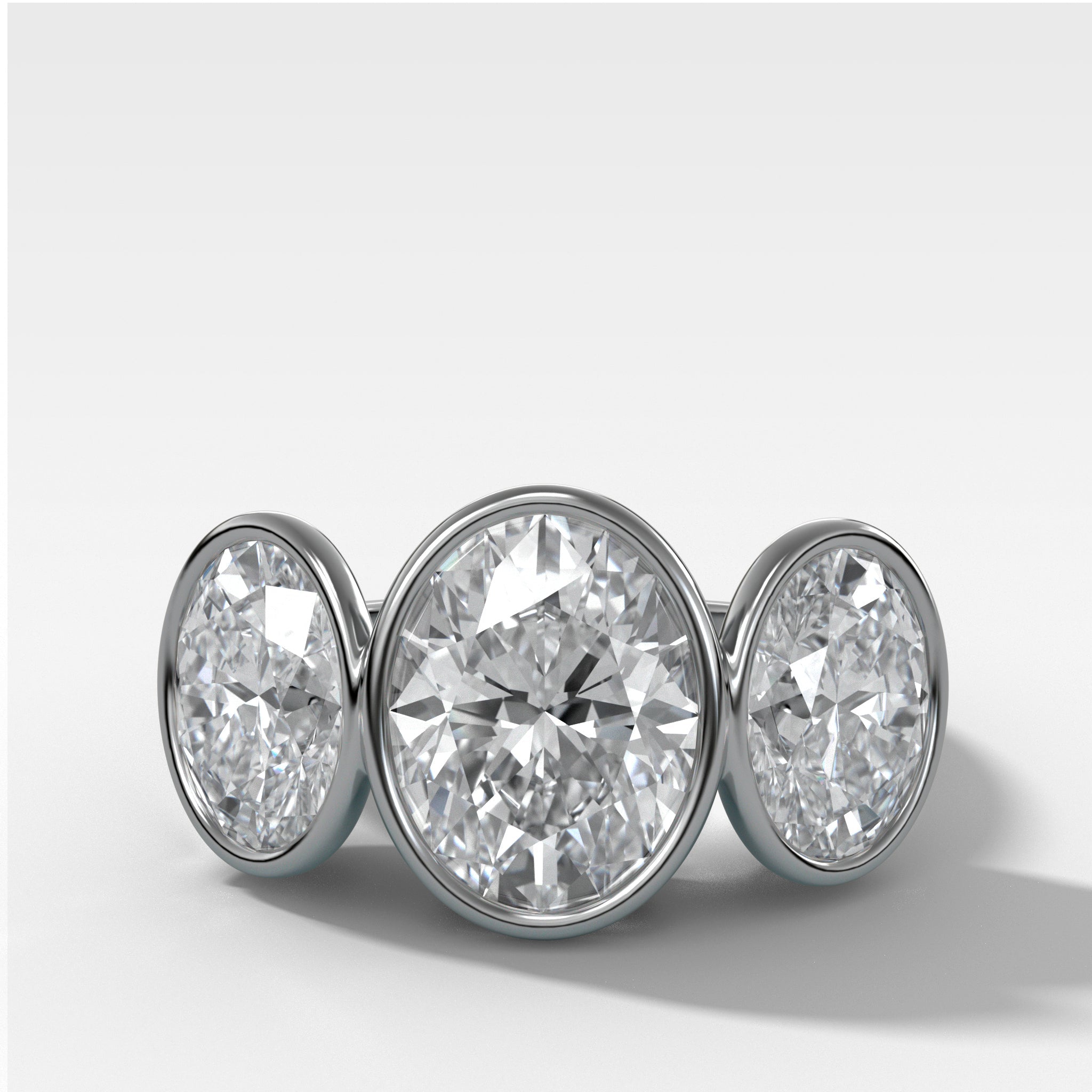 Penumbra Bezel Triad Engagement Ring With Oval Cut Diamonds