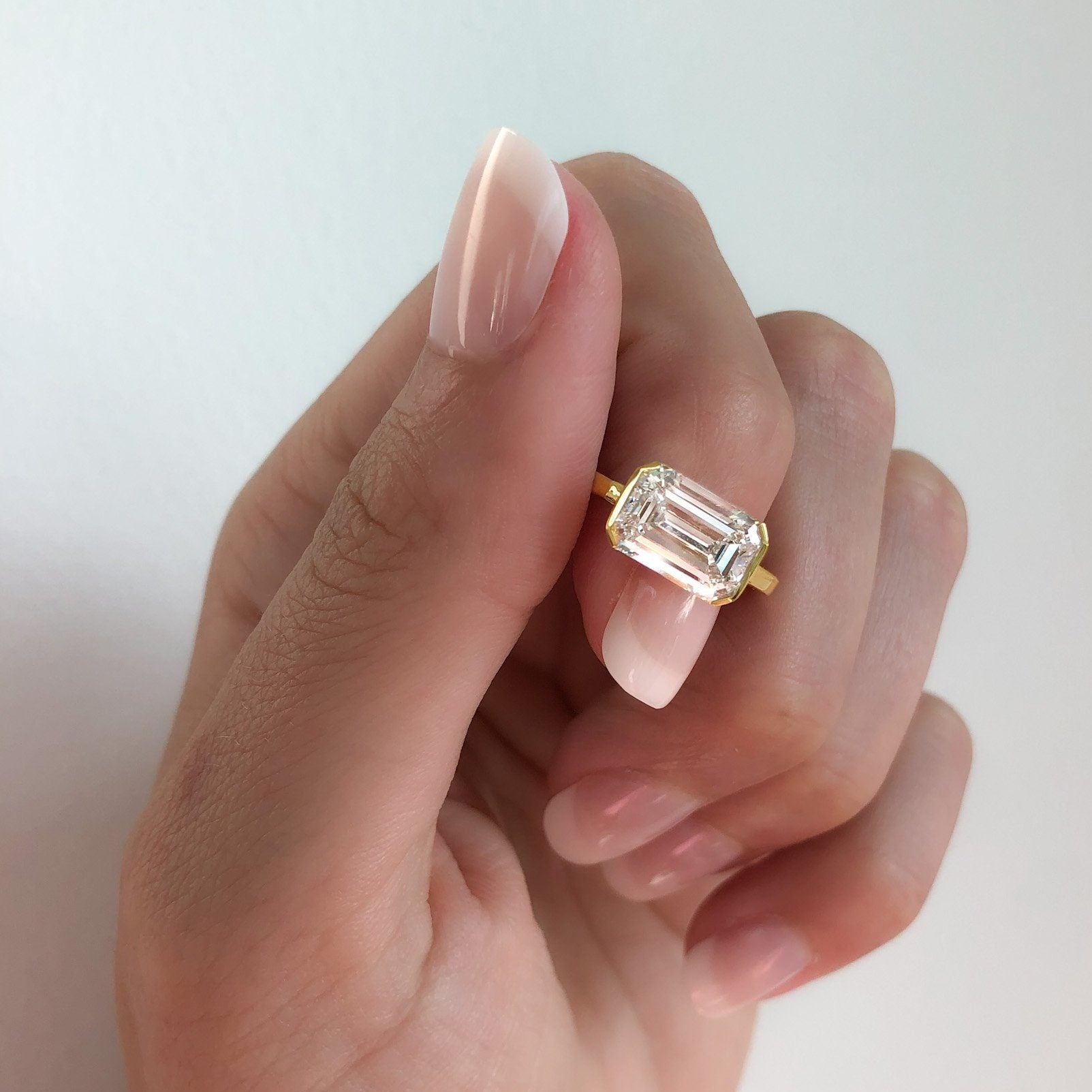 East West Half Bezel Solitaire Engagement Ring With Emerald Cut Diamond