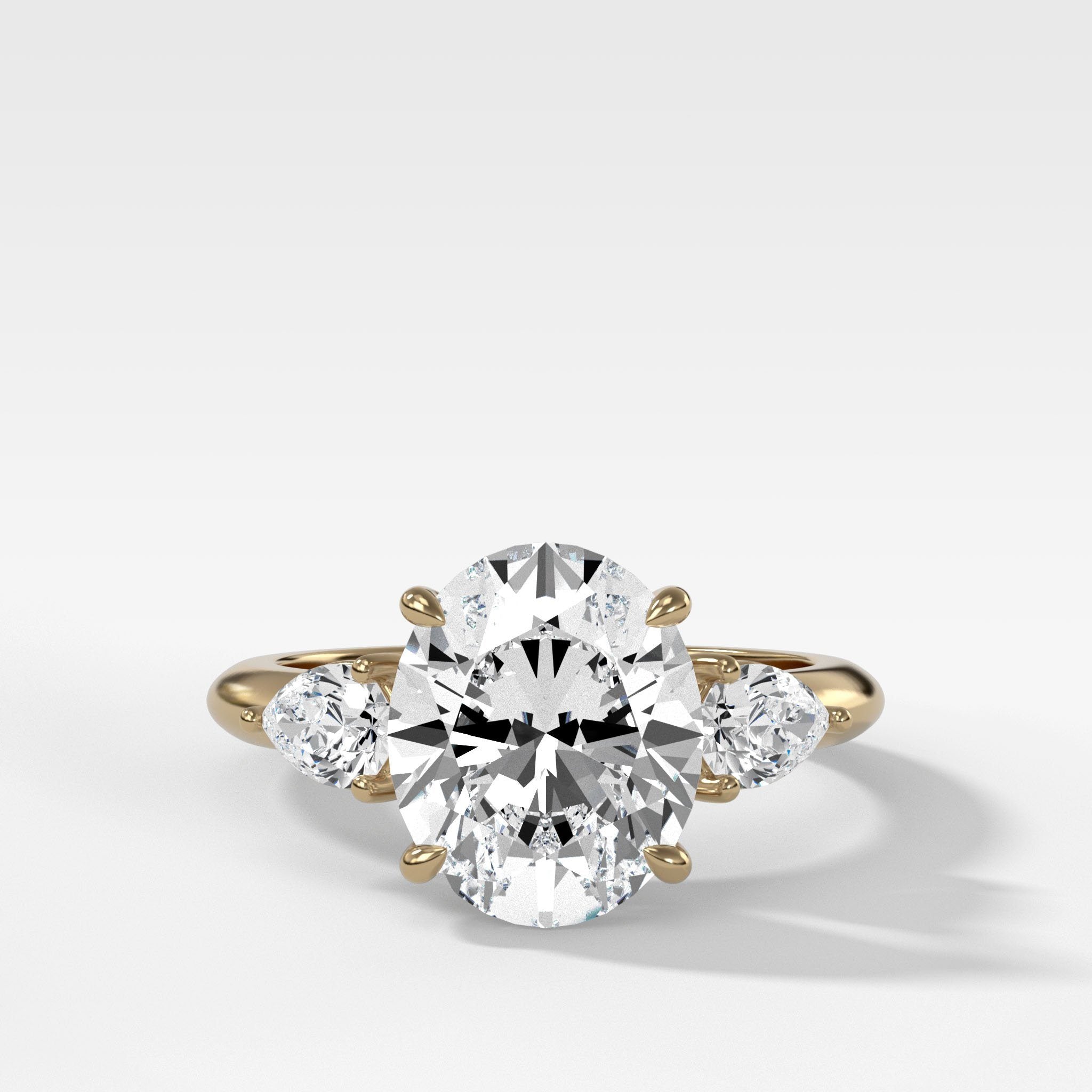 Three Stone Engagement Ring With Pear Side Stones and Oval Cut Diamond