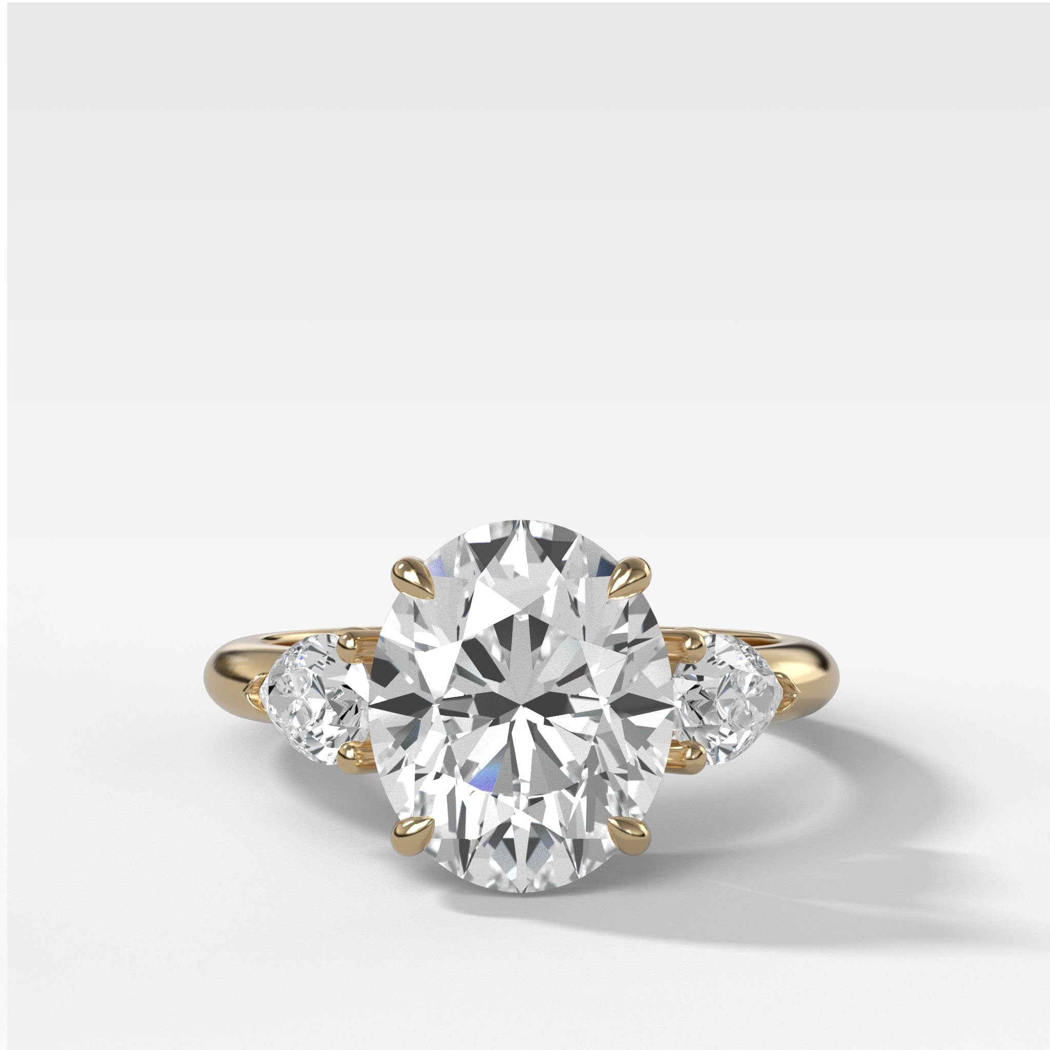 Three Stone Engagement Ring With Pear Side Stones and Oval Cut Diamond