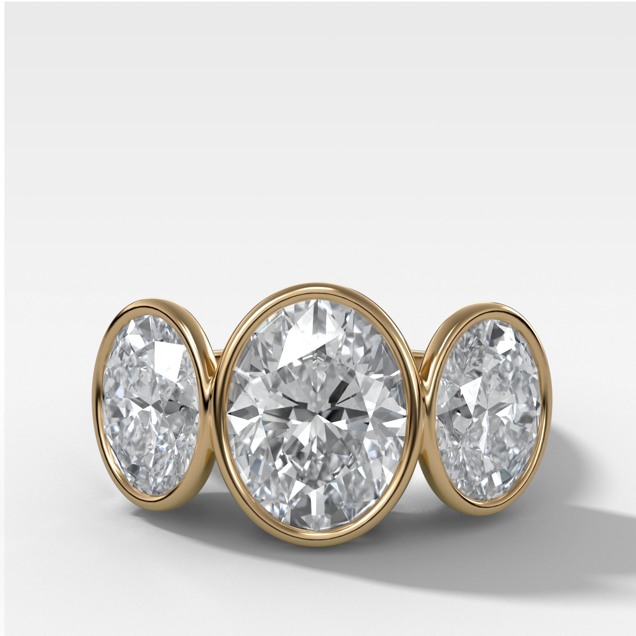 Penumbra Bezel Triad Engagement Ring With Oval Cut Diamonds
